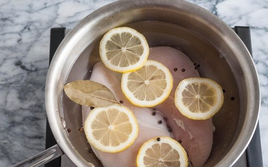 1. Этап. Идеальная отварная куриная грудка: 3. Помойте и нарежьте лимон, порежьте его дольками. Почистите и измельчите чеснок. Положите насколько долек лимона в кастрюлю, добавьте также перец, лавровый лист, соль и чеснок.