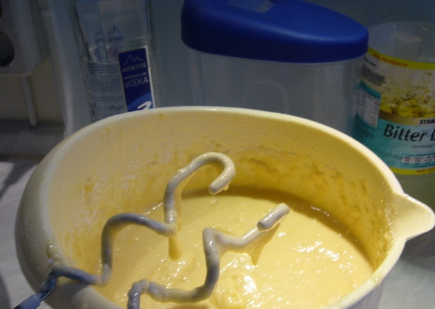 1. Этап. Сливочный кекс Водка с лимоном: Смените насадку на крюк, просейте муку с разрыхлителем и цедрой лимона. Частями добавляйте сухие ингредиенты, замесив тесто, по консистенции напоминающее густую сметану.