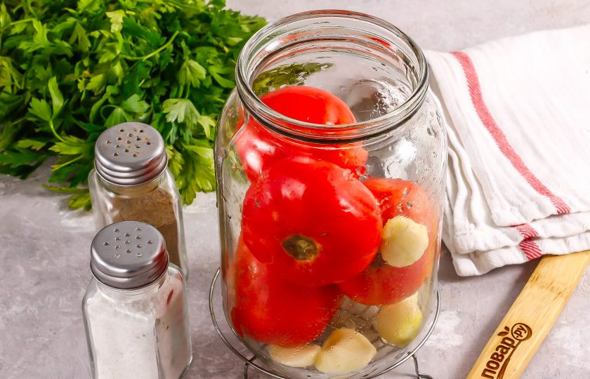 1. Этап. Розовые помидоры на зиму: Промойте помидоры. Очистите зубчики чеснока и выложите все в чистую промытую банку.