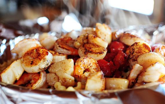 1. Этап. Паста с морепродуктами и помидорами: 6. Выложить сверху морепродукты. Соединить два противоположных края фольги с обеих сторон, чтобы запечатать блюдо. Поставить форму в духовку и выпекать в течение 15 минут, до тех пор, пока морепродукты не будут полностью готовы.