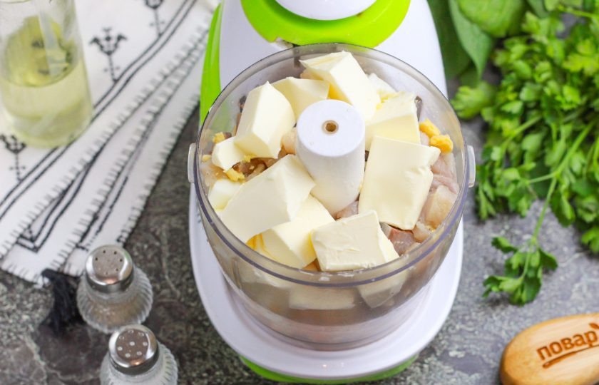 1. Этап. Селедочное масло классический рецепт: Выложите нарезки в емкость измельчителя и нарежьте туда же мягкое сливочное масло. Масло маргарином или спредом заменять нельзя!