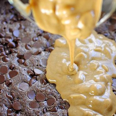 1. Этап. Шоколадные пирожные с орехами и суфле: 5. Тем временем смешать арахисовое масло и рапсовое масло и нагреть в микроволновой печи в течение 20 секунд, чтобы размягчить. Вылить эту теплую смесь поверх горячего теста и равномерно распределить.