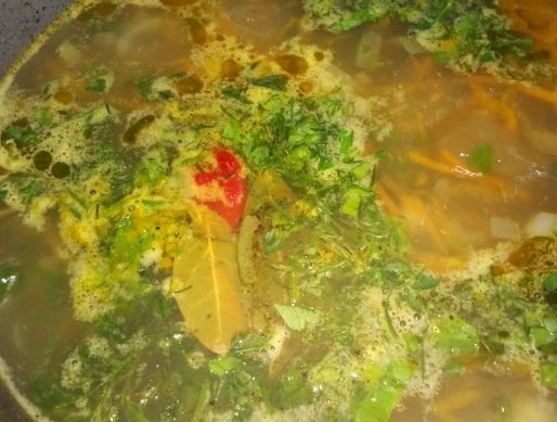 1. Этап. Лососевый суп: 11. Отправляю зелень в суп, по вкусу солю и перчу, кладу половинку перца чили и провариваю около 3-5 минут, затем выключаю.