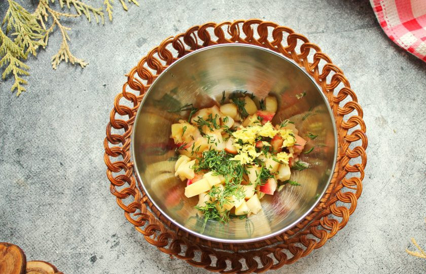 1. Этап. Салат с крабом и персиками: Имбирь почистите и натрите на мелкой терке, зелень мелко порежьте. Добавьте имбирь и зелень в миску с персиками.