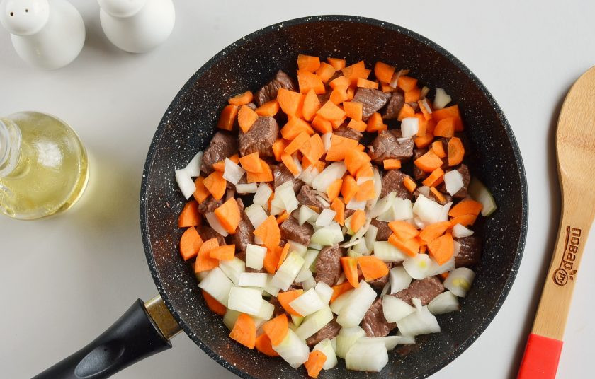 1. Этап. Тушеная телятина с подливкой: Добавьте морковь и лук, обжаривайте еще минут 5.