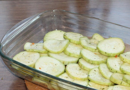 1. Этап. Запеканка с картофелем, кабачками, мясным фаршем: 10. Включите духовку для разогрева до 180 градусов. Дно формы для запекания щедро смажьте подсолнечным маслом и выложите половину кабачков.