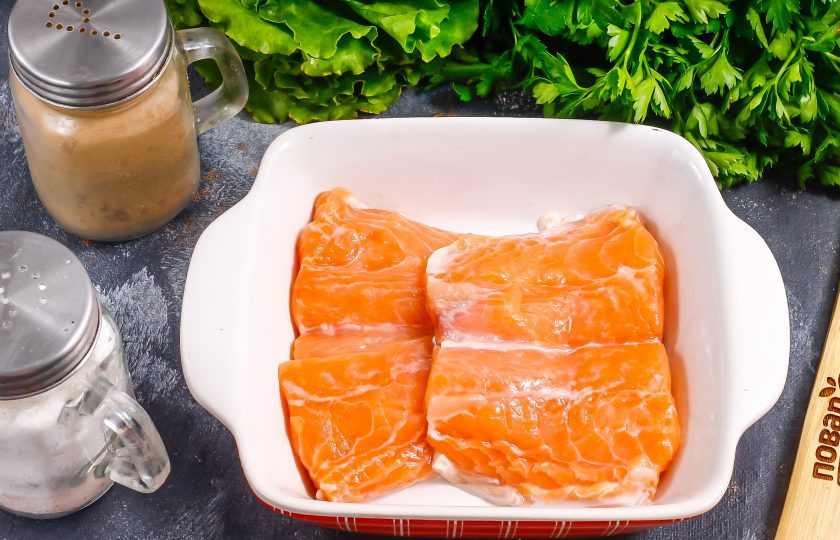 1. Этап. Засол красной рыбы с водкой: Разрежьте кусочек рыбы на две части, срежьте аккуратно хребет и мякоть с кожи. Тщательно промойте в воде, исключая мелкие частички чешуи. Промокните кусочки рыбы бумажными салфетками и выложите в глубокую емкость.