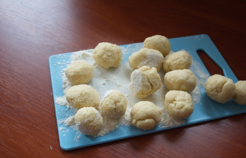 1. Этап. Печенье на кефире в духовке: Кладем тесто в пакет и помещаем в морозилку на 1 час. Из полученного теста формируем небольшие шарики. Приплюсните каждый шарик (стаканом, формочкой или другим предметом) для получения ровного плоского круга. После выпечки рисунок на печенье исчезнет, поэтому не надо особо стараться в этом плане.