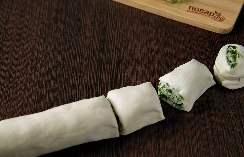 1. Этап. Лепешки с укропом: Скрутите тесто рулетом, защипните по краю и нарежьте на кусочки одинаковой величины. Размер кусочков зависит от желаемого размера лепешек.