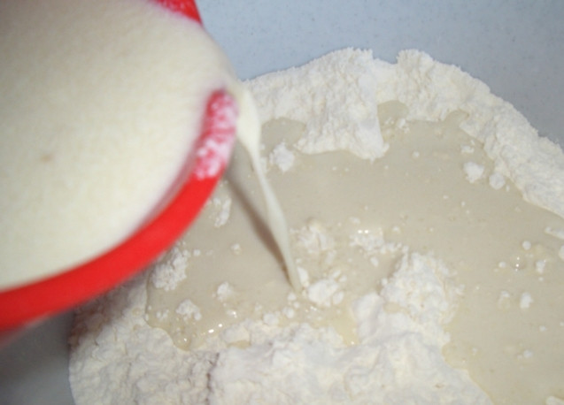 1. Этап. Пончики на простокваше: 3. Влейте в муку взбитые с простоквашей яйца, растворившиеся дрожжи, добавьте немного соли.