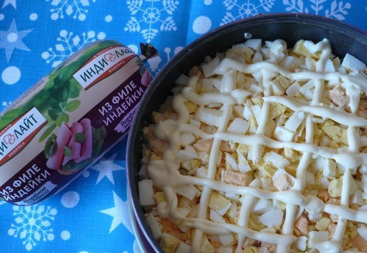 1. Этап. Салат к Новогоднему столу: Вареные яйца очистить и нарезать кубиками. Выложить их поверх слоя ананаса и снова сделать сеточку майонезом.