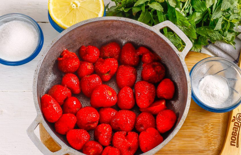 1. Этап. Клубничное варенье с пектином: Клубнику промойте в воде, удалите хвостики с ягод и высыпьте их в казан или ковш с антипригарным дном. Если ягоды крупные, то разрежьте их пополам.