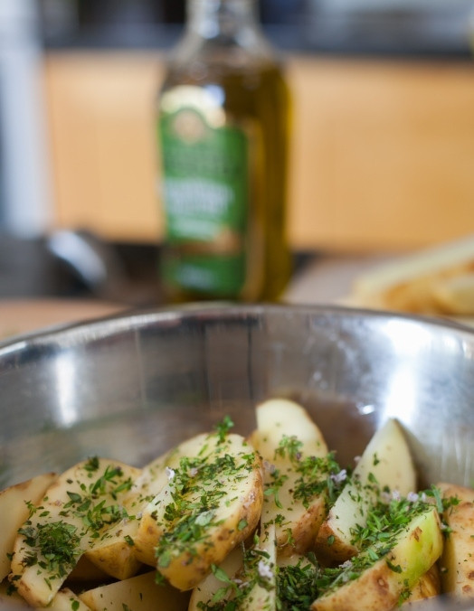 1. Этап. Запечённые говяжьи рёбрышки: Нарежьте картофель дольками и посыпьте зеленью. Выложите в форму для запекания. Поставьте в духовку за 20 минут до того, как приготовятся рёбрышки. Увеличьте огонь до 220 градусов. Картофель и рёбрышки подойдут одновременно.