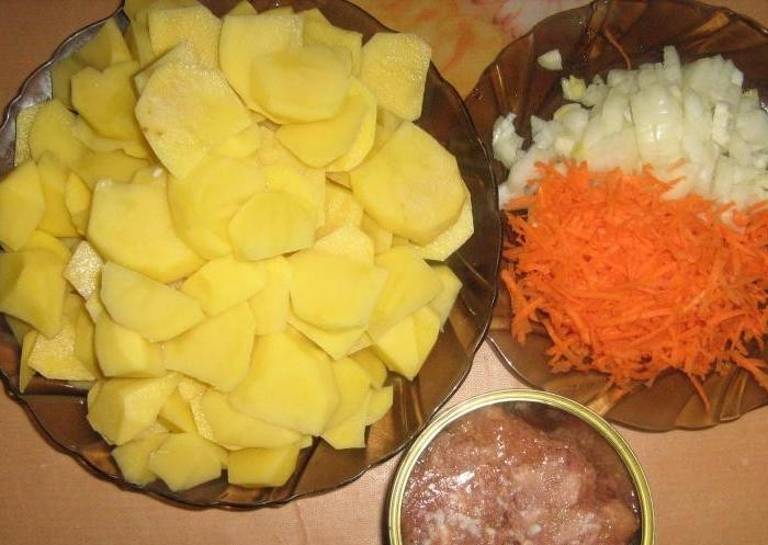 1. Этап. Картошка с тушенкой: Для начала подготовим основные ингредиенты. Лук, картошку, морковь почистим. Лук нарежем мелко, картофель - крупно, а морковь натрем на средней терке.