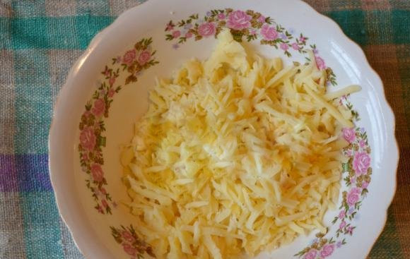 1. Этап. Слоеный пирог с сыром и зеленью: Твердый сыр натрите в отдельную тарелку на терке. Крупно или мелко вы его натрете — особого значения не имеет, так что выбирайте сами, как это сделать.