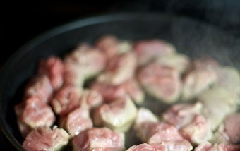 1. Этап. Мясо с лисичками: В сковородку наливаем столовую ложку масла и на сильном огне обжариваем в нем кусочки мяса, все время перемешивая их.