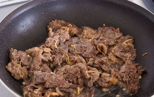 1. Этап. Брокколи и говядина: 3. Чеснок измельчите, а имбирь нарежьте тонкой соломкой. В сотейнике разогрейте растительное масло, добавьте чеснок и имбирь, выложите говядину и обжарьте, чтобы мясо схватилось, сразу же переложите в отдельную миску.