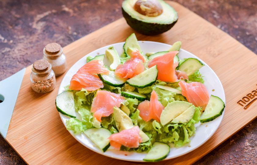 1. Этап. Салат с форелью и авокадо: Поверх салата разложите небольшие кусочки форели. Сбрызните салат слегка маслом, по желанию лимонным соком, добавьте соль и перец.