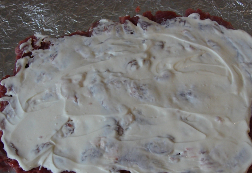 1. Этап. Рулет из индейки в фольге: Выкладываем мясо на фольгу, смазываем сметаной.