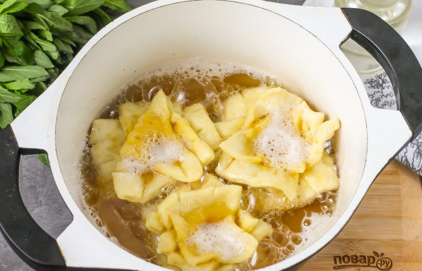 1. Этап. Хворост Розочки: Разогрейте в казане растительное масло до кипения и выложите в него заготовки. Обжарьте снизу до румяности, затем аккуратно переверните на другую сторону.