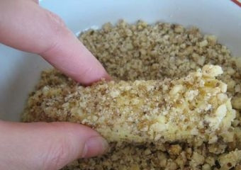 1. Этап. Сырные трубочки с острой начинкой: 5. Грецкие орехи измельчаю в крошку, затем обваливаю трубочку со всех сторон в ореховой панировке.