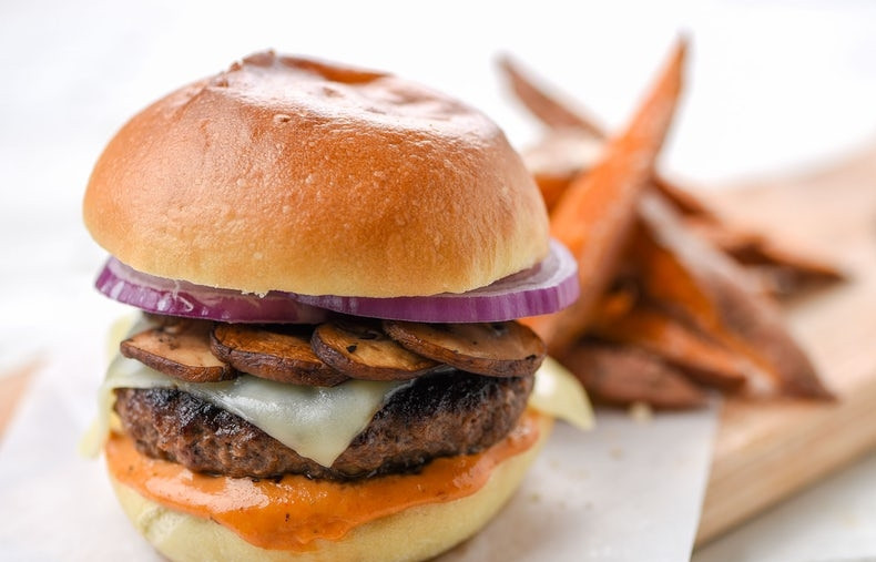 1. Этап. Умами бургер: 6. Соберите бургеры. Булочки смажьте соусом, на него выложите котлету. Затем - кусок сыра и грибы. Пару колец лука и сверху булочка с соусом. Подавайте бургер с бататом. Приятного аппетита!