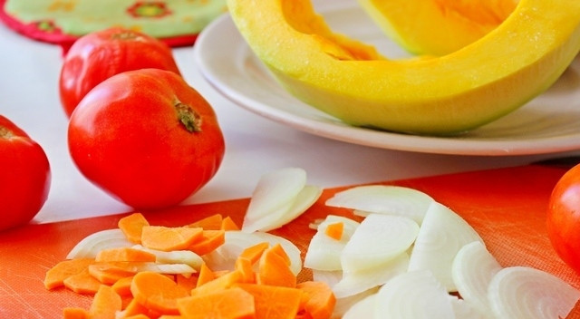 1. Этап. Томатно-тыквенный суп-пюре: Шаг 2. Порежьте картофель и очищенную от кожуры тыкву кубиками среднего размера. Положите их в кастрюлю с бульоном и поставьте на огонь. Порежьте мелко лук и морковь. Слегка обжарьте их на сковороде с небольшим количеством масла.