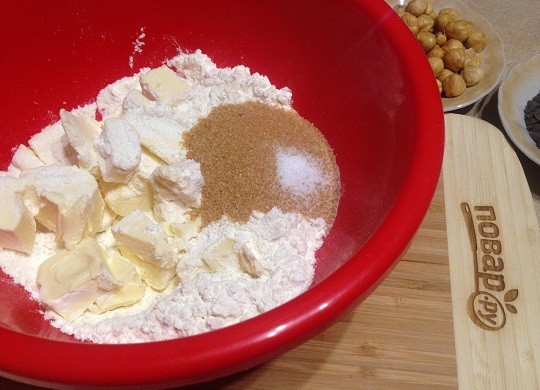 1. Этап. Песочное печенье с фундуком и шоколадом: 2. В миску просеиваем муку, добавляем сахар, соль и порубленное на кусочки холодное сливочное масло. Быстренько перетираем или рубим ножом в крошку.