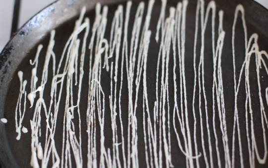 1. Этап. Тесто Катаифи: Разогрейте сковороду. Не добавляя на неё масла, налейте тесто тонкой струйкой, чтобы получилась ажурная сетка. Обжаривать такую сетку нужно в течение 15 секунд с одной стороны, затем нужно сразу выложить сетку в тарелку.