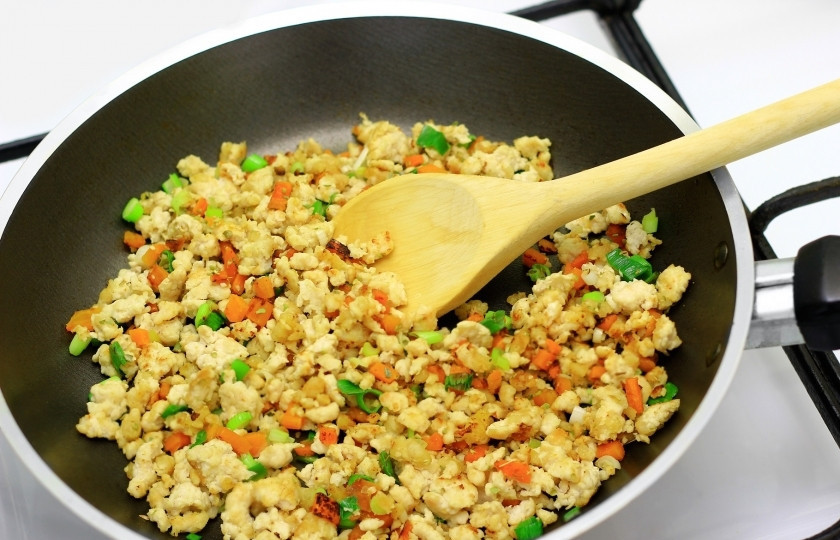 1. Этап. Салат Русская красавица с грибами: Очень мелко нарежьте куриное филе, а лучше пропустите через мясорубку. Нарубите репчатый и зелёный лук, так же мелко нарежьте морковь. Сковороду полейте растительным маслом, разогрейте и закиньте куриное филе, репчатый и зелёной лук и морковь. Тушите до полной готовности куриного мяса.