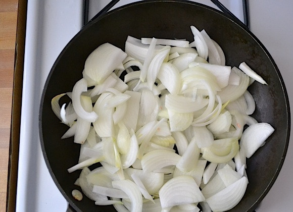 1. Этап. Пицца со сливочным соусом: 2. Очистите лук, нарежьте его. Добавьте лук в сковороду с разогретым оливковым маслом и готовьте на маленьком огне, периодически помешивая.