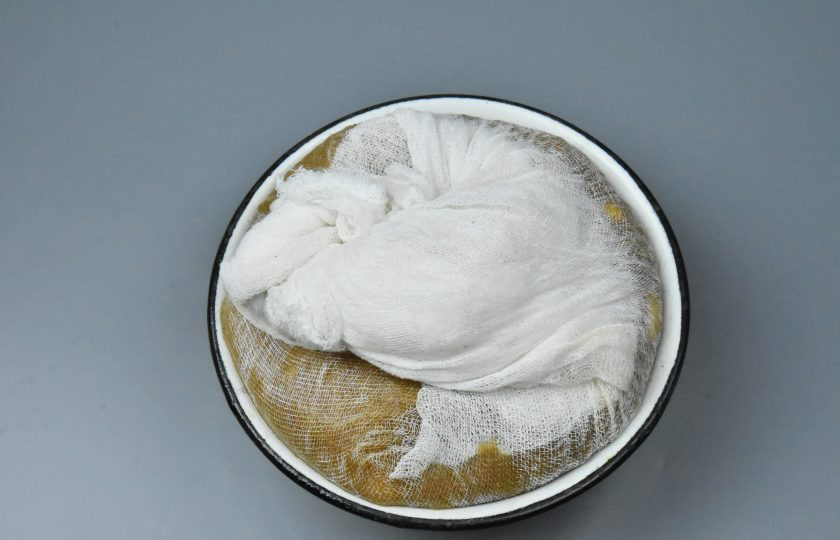 1. Этап. Яблочный сыр: Соберите концы марли сверху, и поставьте груз. Форму установите в посуду, куда будет стекать лишняя влага. Оставьте полуфабрикат на сутки. После чего яблочный сыр необходимо подвесить в сухом месте либо выложить на поверхность и подсушивать его периодически переворачивая.