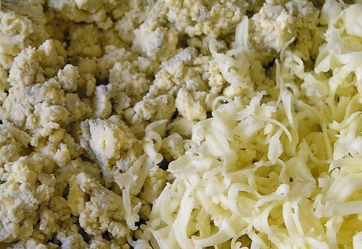 1. Этап. Закуска из яиц в красном соусе: Разомните желтки вилкой вместе с молоком. Добавьте половину тертого сыра, измельченный чеснок, посолите, поперчите и перемешайте.