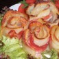 Картофельные розы Очищенный картофель нарезать тонкими ломтиками (с помощью овощерезки). На полоску бекона выложить ломтики картофеля внахлёст. Скрутить картофель с беконом (как на фото), выложить в формочки для маффинов. Смешать молотые сухари с тёртым сыром, присыпать наши