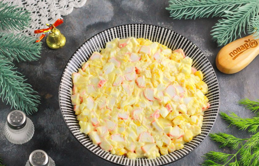 1. Этап. Крабовый салат на Новый год 2025: В пиалу или креманку выложите крабовый салат и аккуратно его утрамбуйте столовой ложкой.