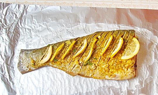 1. Этап. Запеченный толстолоб с лимоном и зеленью: 2. Фольгу смазываем маслом и укладываем в нее маринованную рыбу, тонко нарезанные ломтики лимона, вставляем в проделанные боковые надрезы.