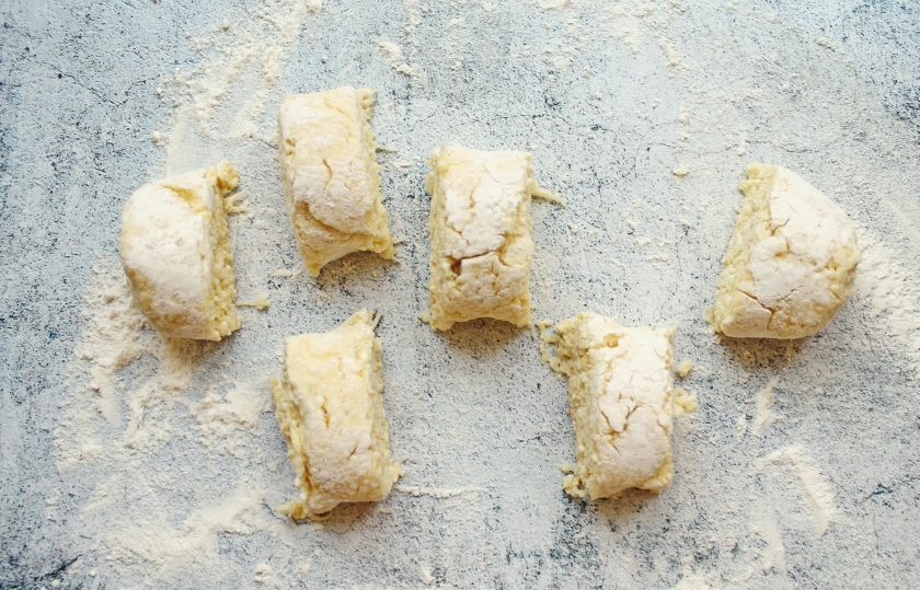 1. Этап. Сырники с топинамбуром: Рабочую поверхность посыпьте мукой и выложите тесто. Сформируйте из теста колбаску и разрежьте ее на 6 частей.