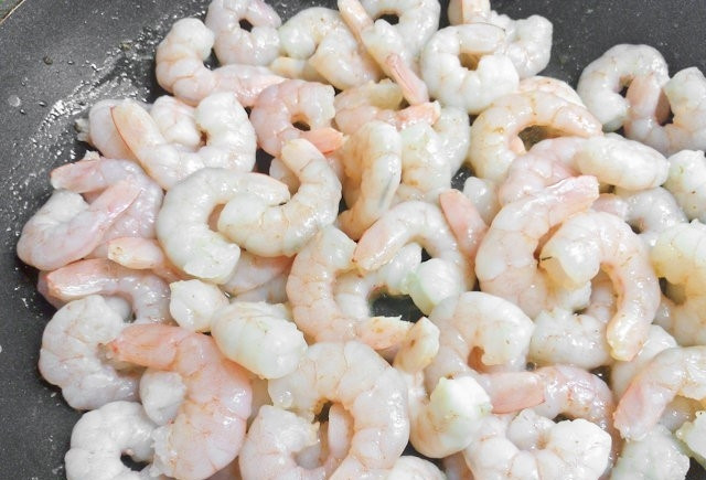 1. Этап. Фетучини с морепродуктами в сливочном соусе: 3. Уберите чеснок со сковороды. Добавьте в масло креветки, обжарьте их на небольшом огне.