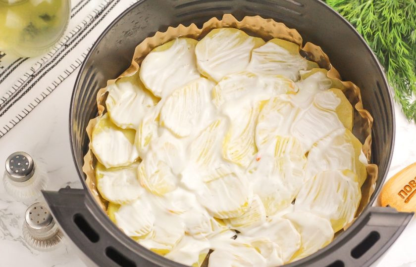 1. Этап. Мясо по-французски в аэрогриле: Аккуратно смажьте картофельный слой сметаной любой жирности или майонезом. Можно просто сбрызнуть растительным маслом. Запеките картофель 10 минут при температуре 180 градусов. Помните, что нарезка не должна быть слишком толстой.