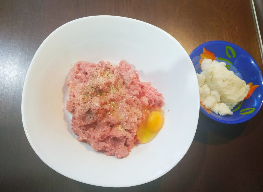 1. Этап. Вареные котлеты: В глубокую миску выложите фарш, добавьте яйцо, размоченный в воде ломтик хлеба и специи.