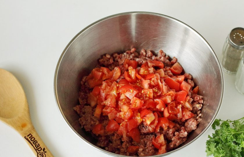 1. Этап. Фаршированные перцы с фаршем и помидорами: Фарш переложите в глубокую миску. Добавьте нарезанные кубиками помидоры.