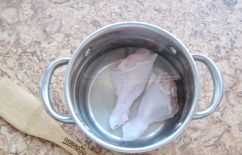 1. Этап. Солянка как в ресторане: Куриные голени помойте, выложите в кастрюлю и залейте водой. Поставьте кастрюлю на плиту.
