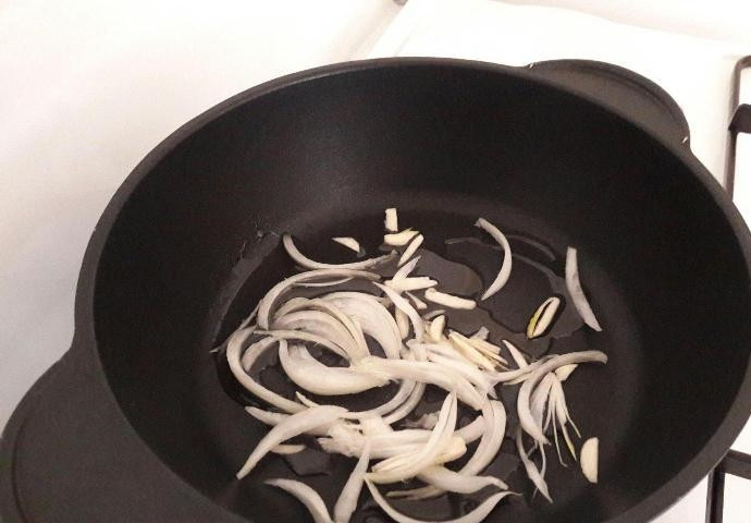 1. Этап. Мерлуза с овощами: В разогретом масле обжарьте пару минут чеснок с луком.