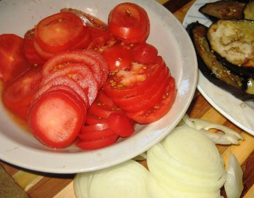 1. Этап. Свинина, запеченная с баклажанами в духовке: Режем колечками лук и помидоры.