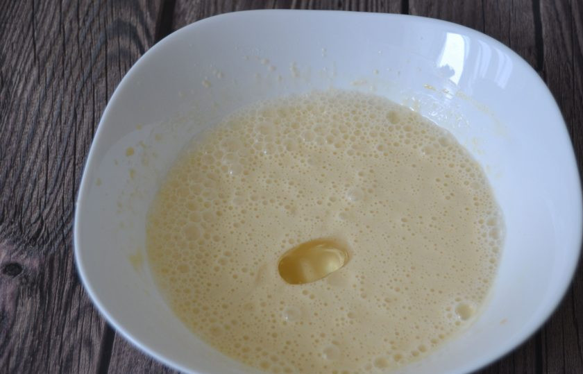 1. Этап. Блины Вологодское кружево: Влейте кипяток с содой в тесто, взбейте, добавьте растительное масло.