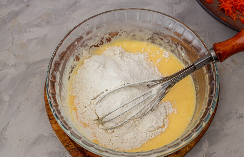 1. Этап. Торт морковный на сковороде: Добавьте просеянную муку и разрыхлитель. Перемешайте до однородного теста.