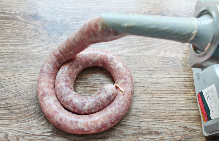 1. Этап. Домашняя колбаса на сковороде: Подготовленную кишку наденьте на специальную насадку для мясорубки, завяжите другой конец и заполните ее фаршем.