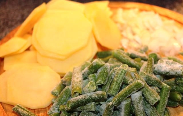 1. Этап. Говяжьи отбивные с чесноком: Собственно, отбивные готовы, и осталось лишь приготовить к ним гарнир. Гарнир я готовлю так: обжариваю в масле мелко нарезанный лук до прозрачности, потом добавляю картофель, жарю их вместе 10 минут, затем добавляю стручковую фасоль и тушу под крышкой на среднем огне около 10 минут.