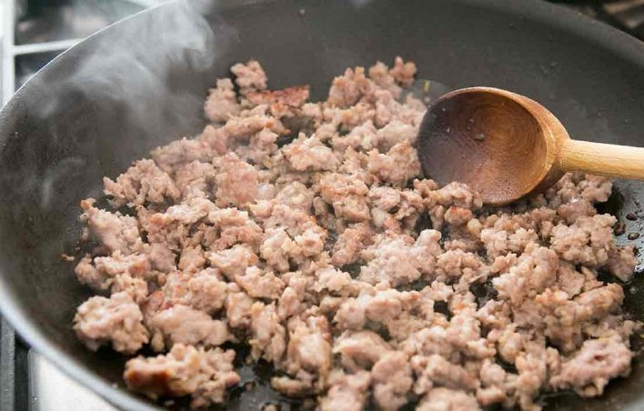 1. Этап. Запеченные спагетти: 1. Отварите спагетти в подсоленной воде, тем временем приступайте к остальным ингредиентам. Сырые свиные колбаски нарежьте кусочками и выложите в разогретую сковороду с оливковым маслом, затем переложите обжаренные колбаки в тарелку.