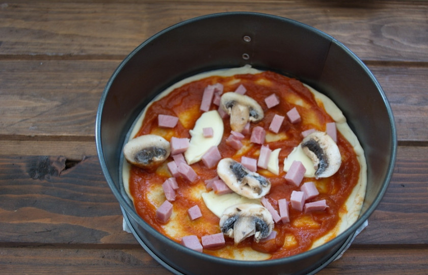 1. Этап. Пицца с шампиньонами, колбасой и сыром: Нарезать колбасу. Нарезать грибы. Выложить начинку так, чтоб она лежала равномерно по всей поверхности.